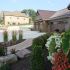 Side view of custom built home with large driveway and lush landscaping